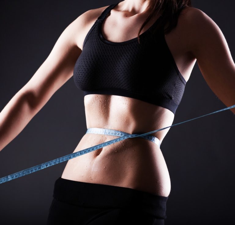 Fitness woman measuring her waist, weight loss