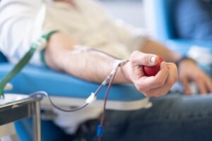 Patient having blood drawn at a medical facility with a tourniquet and collection tube representing the TRT blood work process required before and during testosterone replacement therapy